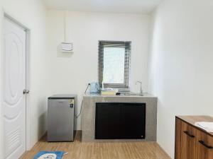 Una cocina con fregadero y encimera con frigorífico. en First Light beach bungalow 2, en Ko Pha Ngan
