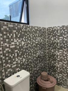 a bathroom with a toilet and a window at A & D Hotel & Restobar in Gasan