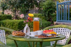 a table with a plate of food and a pitcher of juice at Corbett Calling with Projector Set-Up by StayVista in Rāmnagar