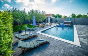 a swimming pool with two lounge chairs and an umbrella at 4 Bedroom Nice Home In Polaca in Polača
