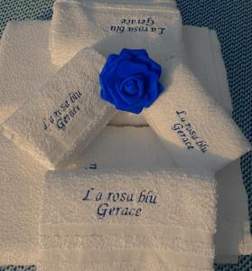 a blue rose sitting on top of white towels at La Rosa Blu in Gerace