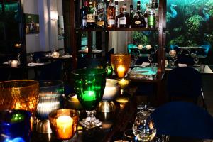 a table in a restaurant with green glasses and candles at The Oriana Orange - Retro Hotel & Resort in Orange