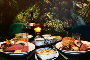 a table with plates of food and glasses of wine at The Oriana Orange - Retro Hotel & Resort in Orange