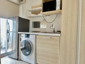 a kitchen with a washing machine and a microwave at Gfeel X Elio Sukhumvit64 in Bangkok