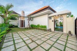 ケロボカンにあるAlicia - Soak Up the Sun - Stylish 2BR Villa with Oversized Poolの家の前に私道があるヴィラ