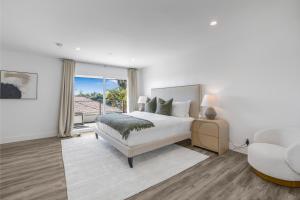 a white bedroom with a bed and a chair at Stradella View in Los Angeles +58 photos