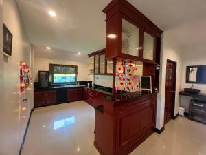 a kitchen with wooden cabinets and a counter top at Purple House - Female only Boutique hostel in Koh Phangan
