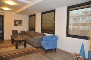 a living room with a couch and a blue chair at Hotel Burgas Free University in Burgas