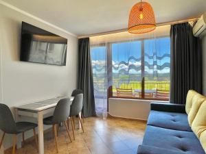 a living room with a blue couch and a table at Arkite - Private apartment - BSR in Sunny Beach
