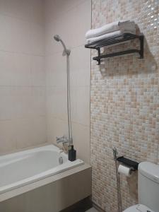 een badkamer met een ligbad en een toilet bij Bali Oma Living in Denpasar