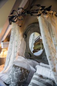 Schlafzimmer mit einem Bett und einem großen Spiegel in der Unterkunft Le B Cottage & SPA Privé in Riquewihr