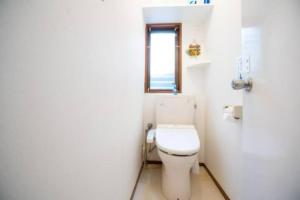 a white bathroom with a toilet and a window at 新宿久久小木屋 整栋出租 in Tokyo