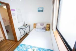 a small room with a bed and a teddy bear at 新宿久久小木屋 整栋出租 in Tokyo