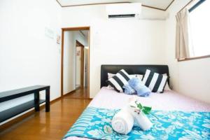 a bedroom with a bed with blue and white pillows at 新宿久久小木屋 整栋出租 in Tokyo
