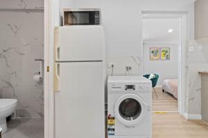 a kitchen with a refrigerator and a washing machine at Stylish 2 Bedroom Unit Close to CBD in Evandale