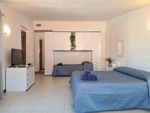 a bedroom with two beds and a television at I Girasoli Apartment - South Sardinia - Capoterra in Capoterra