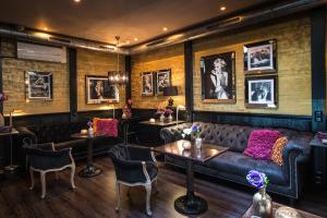 a bar with a leather couch and tables and pictures on the walls at Hotel Sebastians in Amsterdam