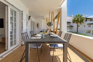 a dining room with a table and chairs on a balcony at Luxurious apartment in Puente Romano, Marbella (Golden Mile) in Marbella