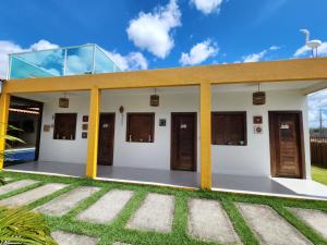 a building with doors and grass in front of it at Casa Amarela - Santo Amaro in Santo Amaro