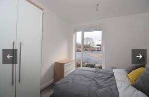 レミントン・スパにあるSunshine Residence - Luxury 2 Bedroom Apartmentのベッドとドレッサーと窓のある寝室