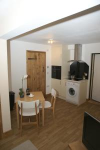 a living room with a table and a kitchen at The Elms Annex in Cottered