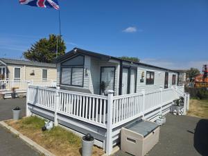 a mobile home with a white railing and a porch at Lyons robin hood HV in Meliden