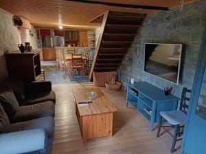 a living room with a couch and a tv and a table at Hotel De Franc Bois in Chimay