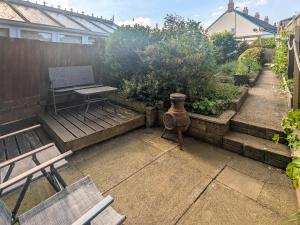 einen kleinen Garten mit einer Bank und einem Tisch in der Unterkunft Trinity Cottage in Abergavenny