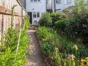 einen Garten mit einem Zaun und ein paar Blumen in der Unterkunft Trinity Cottage in Abergavenny