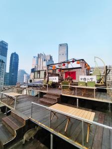 taras z krzesłami i stołami na dachu budynku w obiekcie Chongqing Houlai Rooftop Terrace Youth Hostel候来屋顶露台青年旅舍 w mieście Chongqing