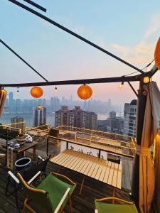 balkon z krzesłami i stołami oraz widokiem na miasto w obiekcie Chongqing Houlai Rooftop Terrace Youth Hostel候来屋顶露台青年旅舍 w mieście Chongqing +100 zdjęć