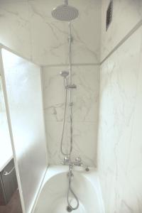 a shower in a bathroom with white marble walls at Superbe appartement a oostende à partir de 36 par nuit in Ostend +10 photos