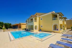 a large house with a swimming pool in front of it at Filippas Rooms in Gouvia in Gouvia