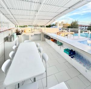 a white table and chairs on a balcony with a pool at Miami Beach Hotel Boracay in Boracay