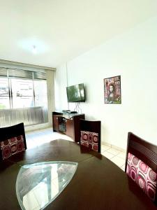 a living room with a glass table and chairs at Apartamento aconchegante no Boqueirão in Santos +9 photos