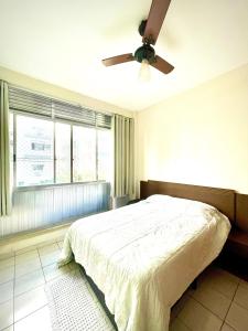 a bedroom with a bed and a ceiling fan at Apartamento aconchegante no Boqueirão in Santos