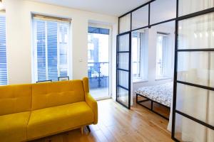 シュチェチンにあるBlack Pearl Apartament Centrumの窓付きの部屋(黄色いソファ付)