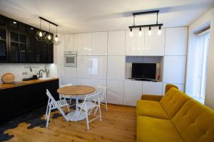 シュチェチンにあるBlack Pearl Apartament Centrumのキッチン、リビングルーム(ソファ、テーブル付)