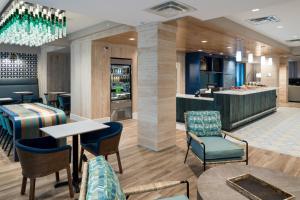 希尔顿黑德岛Courtyard by Marriott Hilton Head Island的酒店大堂，有椅子和酒吧