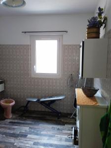 a window in a kitchen with a chair in front of it at chez l'habitant in Lavelanet
