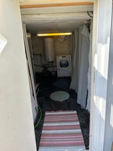 a small bathroom with a washing machine in a room at Söt stuga in Strömstad