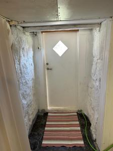 a door in a room with a striped rug at Söt stuga in Strömstad