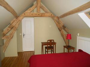 a bedroom with a red bed and a table and chairs at Domaine de Mousseaux, Montbouy in Montbouy