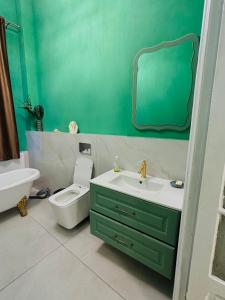 a bathroom with a sink and a toilet and a mirror at LAYA Old City in Bucharest