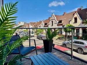 a balcony with a blue chair and plants on a street at MEL&BENS Loft-Appartements Terrasse Weserstadion in Bremen