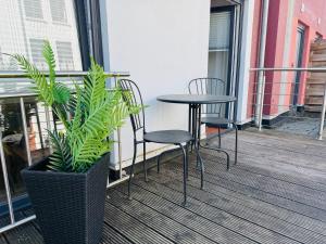 a patio with two chairs and a table and a plant at MEL&BENS Loft-Appartements Terrasse Weserstadion in Bremen