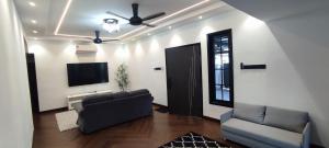 a living room with a couch and a flat screen tv at Akasea Sojourn in Jitra