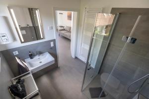 a bathroom with a sink and a glass shower at air bumble bee in Vreden +37 photos