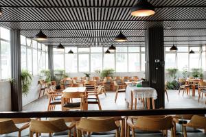a restaurant with wooden tables and chairs and windows at Sky House Hotel Da Lat City in Da Lat