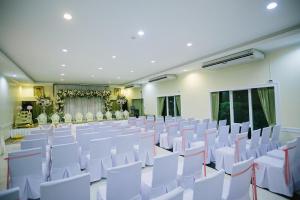 Samut SongkhramにあるAmphawaree Hotelの白い椅子が備わる部屋と
